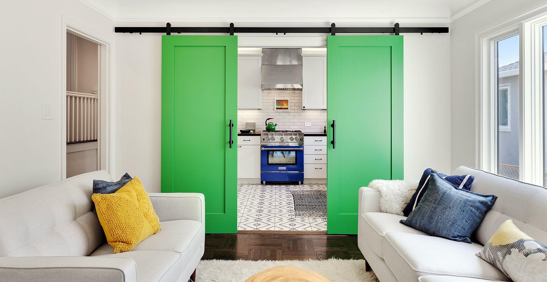 Loki sliding barn door hardware in black finish installed on green bi-parting kitchen doors.