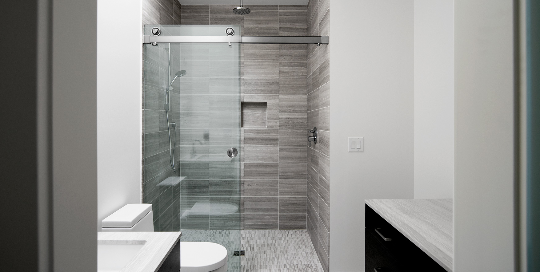 Frameless shower door system in Brushed Stainless finish.