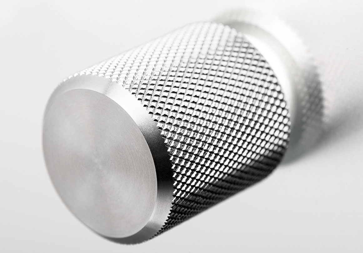 Close-up of Kor Cabinet Knob with knurled texture in Stainless Steel