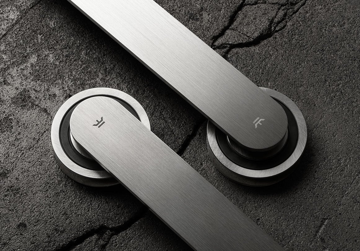 The Oden sliding door hardware system in Brushed Stainless finish on concrete surface