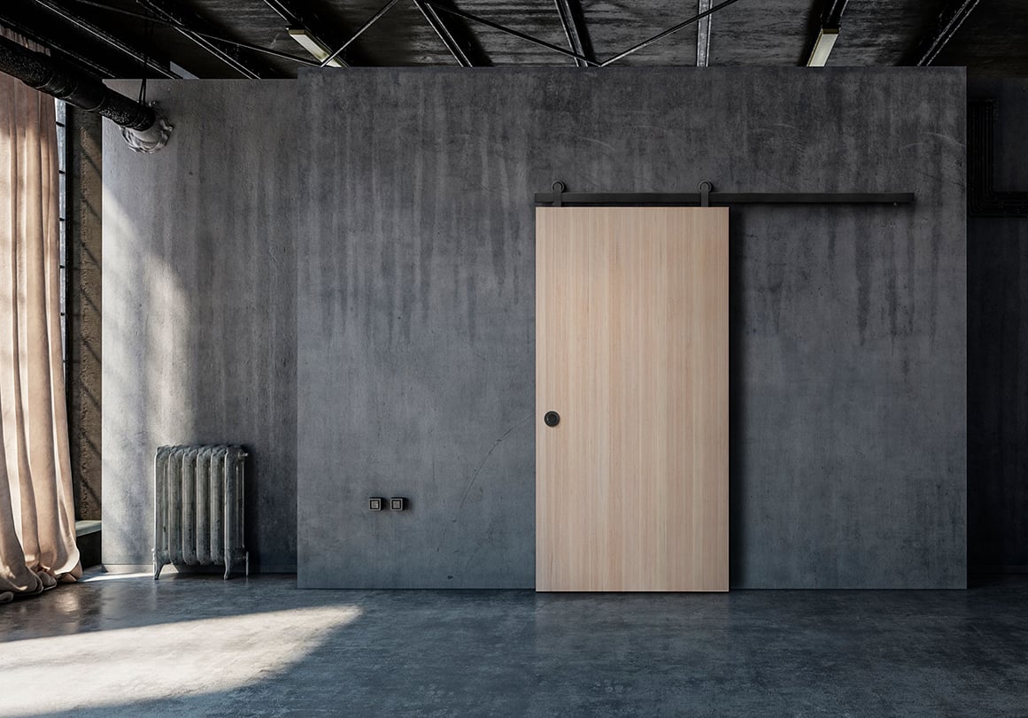 Solid wood door installed with barn door hardware in industrial loft