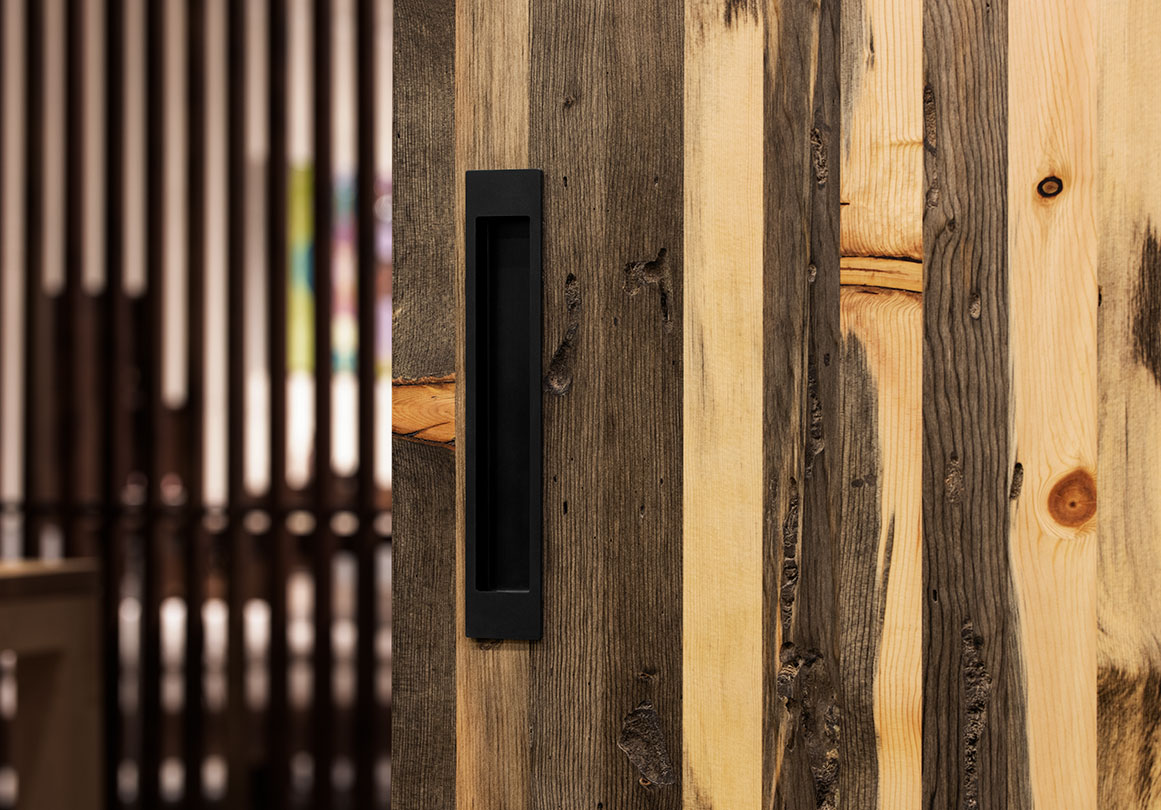 Asta recessed door pull is installed with Variis Barn Door Panel inn Blue Pine.